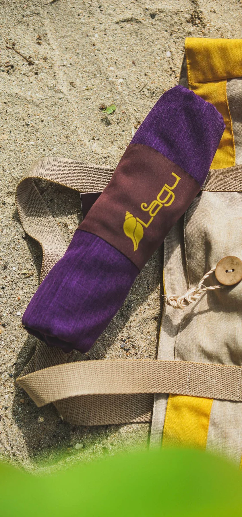 A rolled Lagu blanket tucked into a beach bag